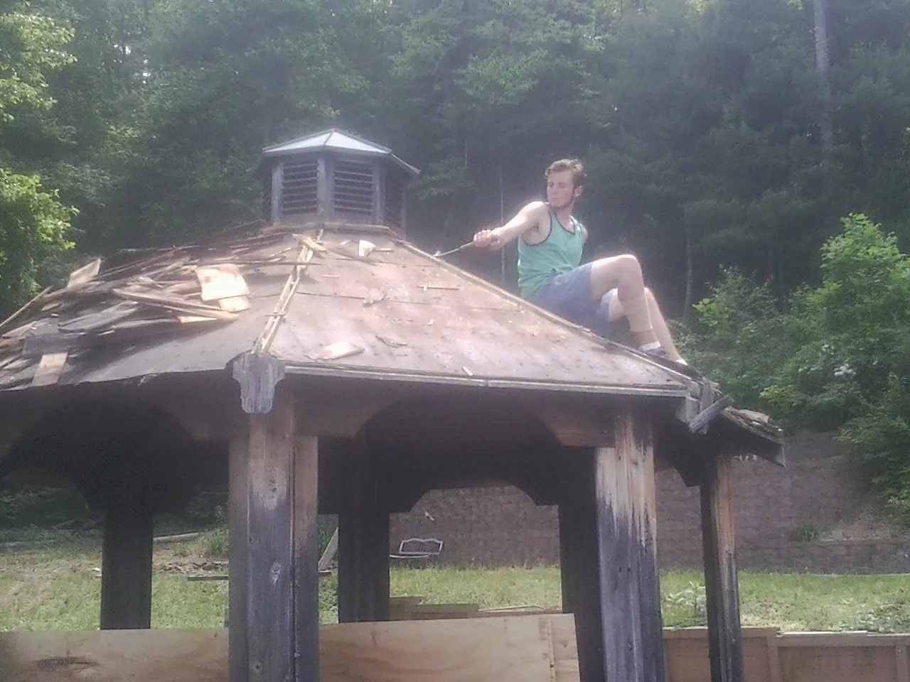 Tearing the old roof off a wooden gazebo before new shakes in Lodi